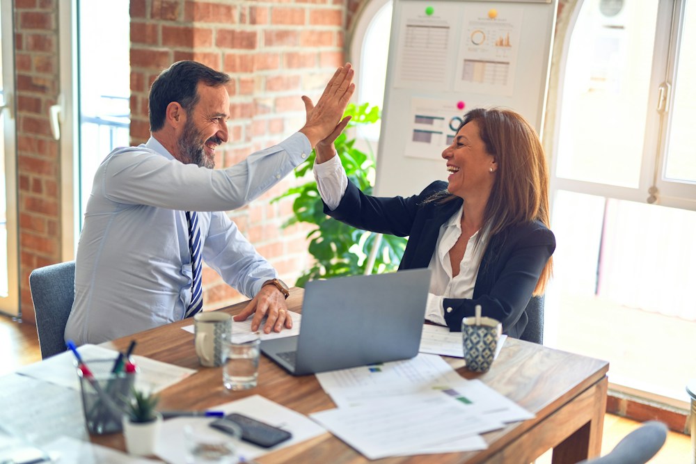Dos personas dialogando y alcanzando un acuerdo en una mesa